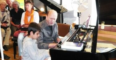 Titelbild: Michael Reimann und Kind am Klavier